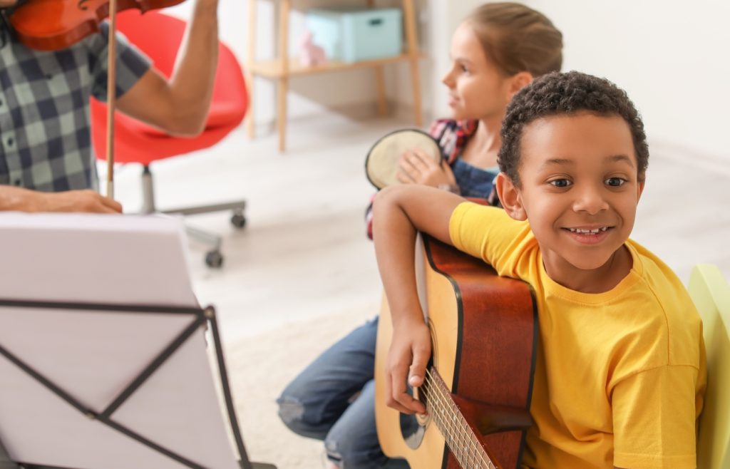 enfant joue de la guitare